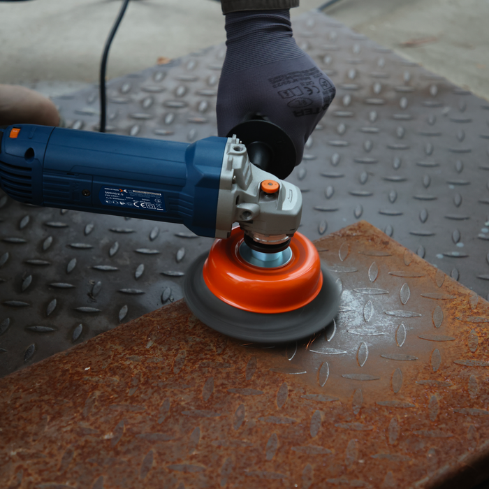 Rebarbadora com fio Dexter 1200W a remover ferrugem de uma chapa de metal