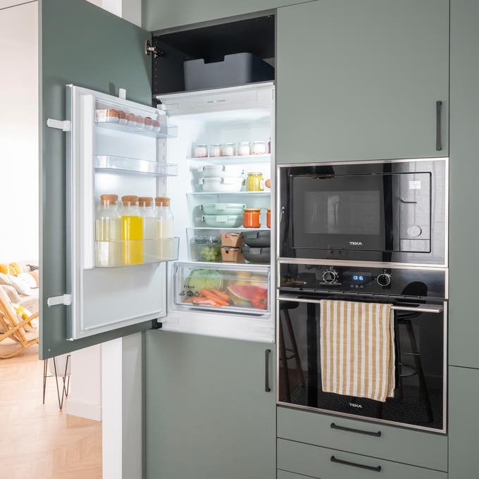 Cocina con muebles en verde y frigorífico integrado