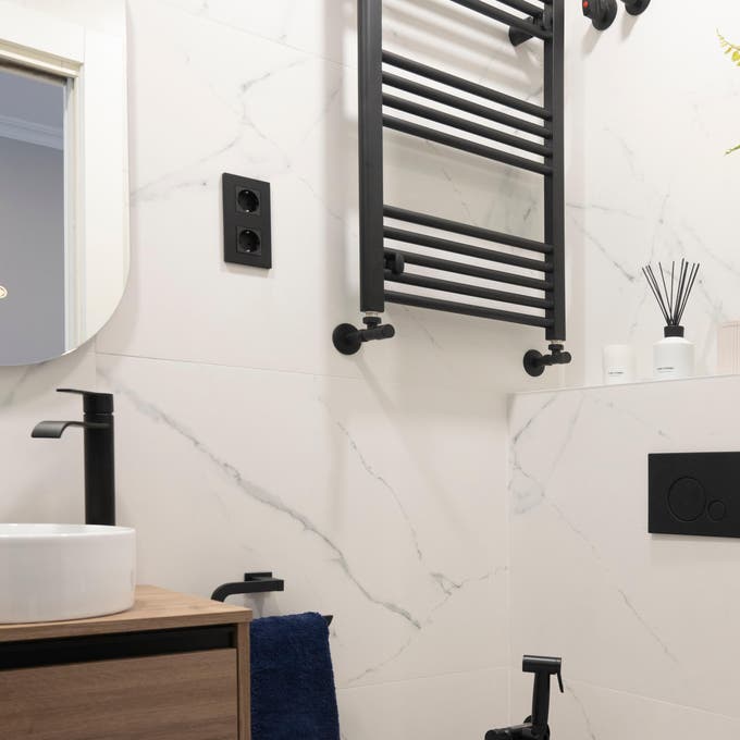Baño con radiador toallero en la pared