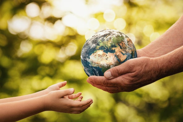 Un signore porge il mondo alle mani di un bimbo