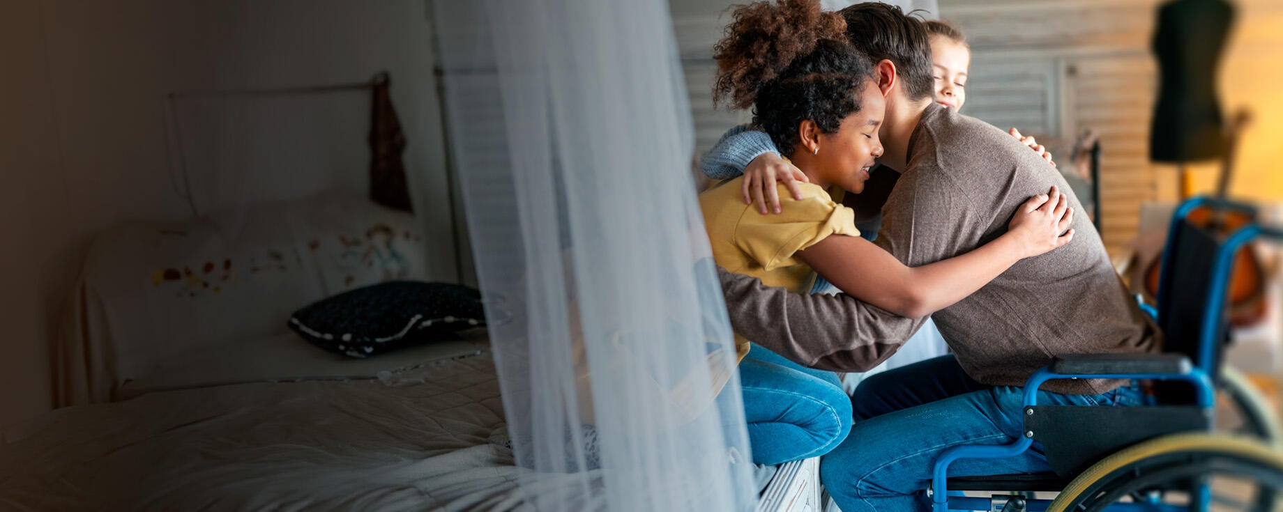 homme en fauteuil qui serre des enfants dans ses bras