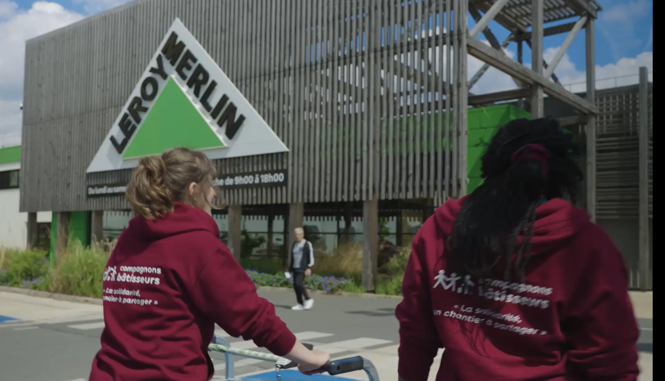 femmes membres d'une association poussant un caddie sur un parking leroy merlin