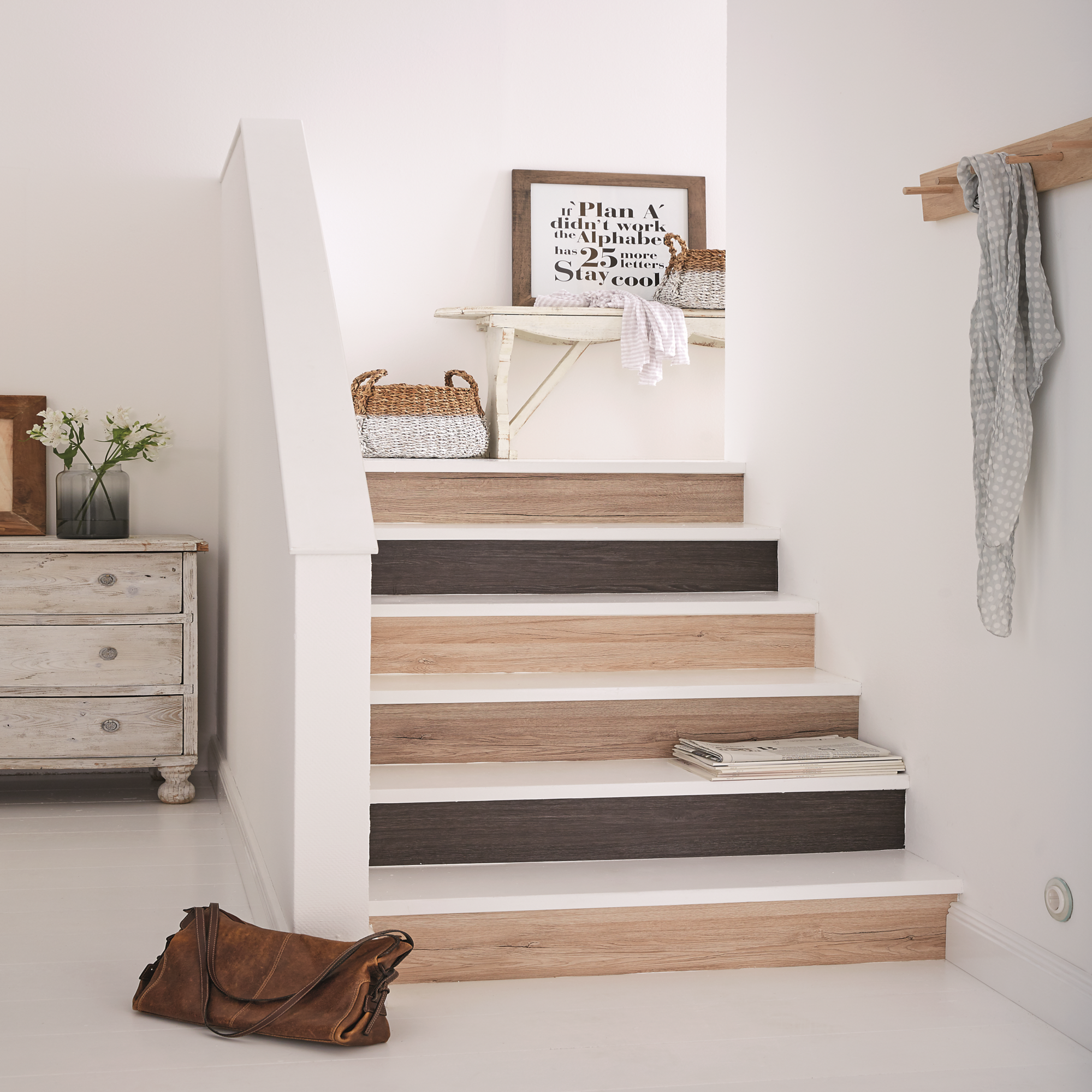 Stopnie schodów ozdobione pasami okleiny.