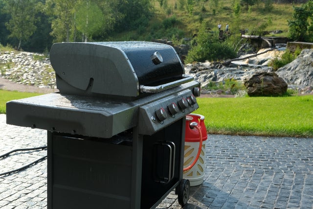 Grill gazowy z butlą obok.