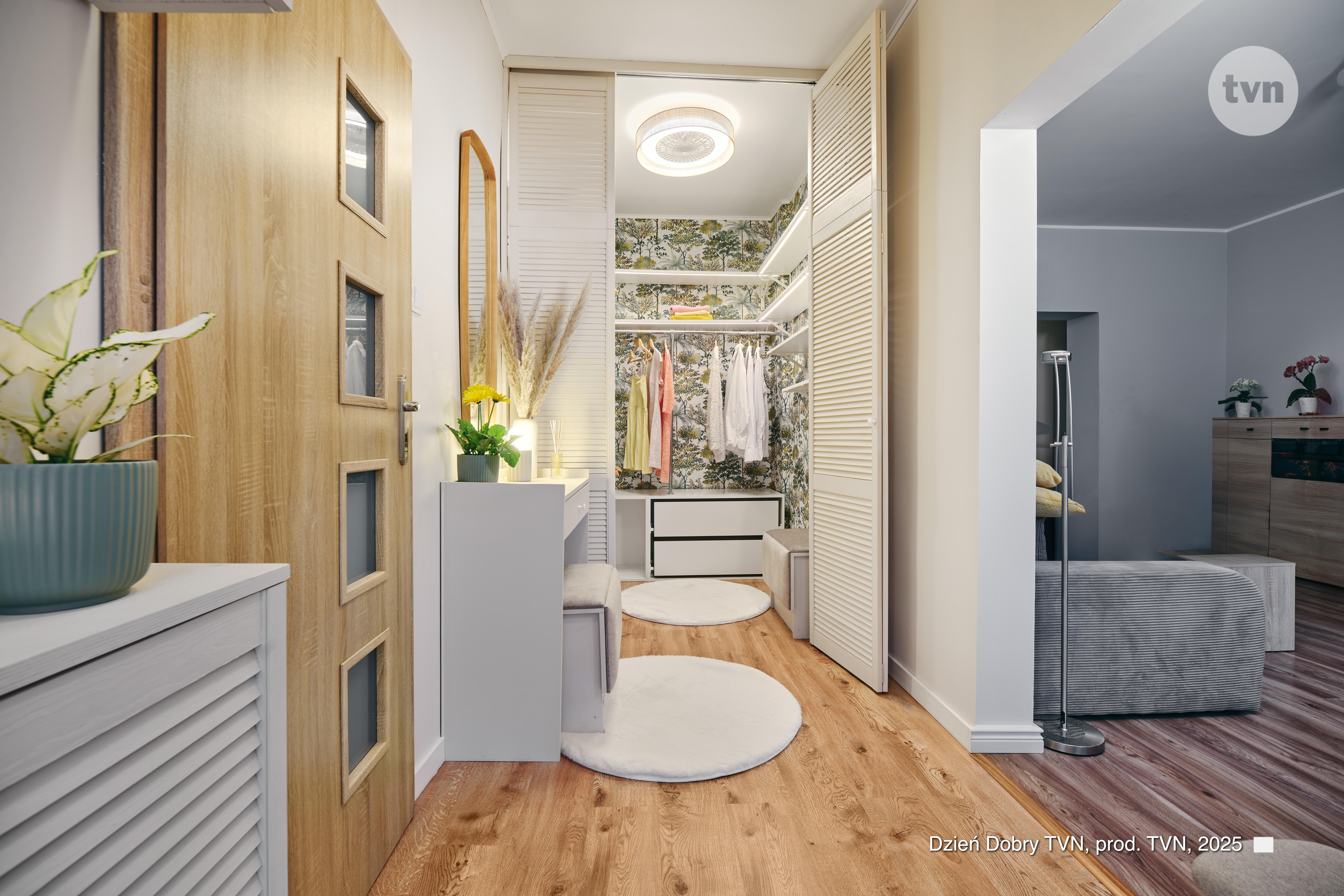Otwarte drzwi do garderoby walk-in, obok widok na salon