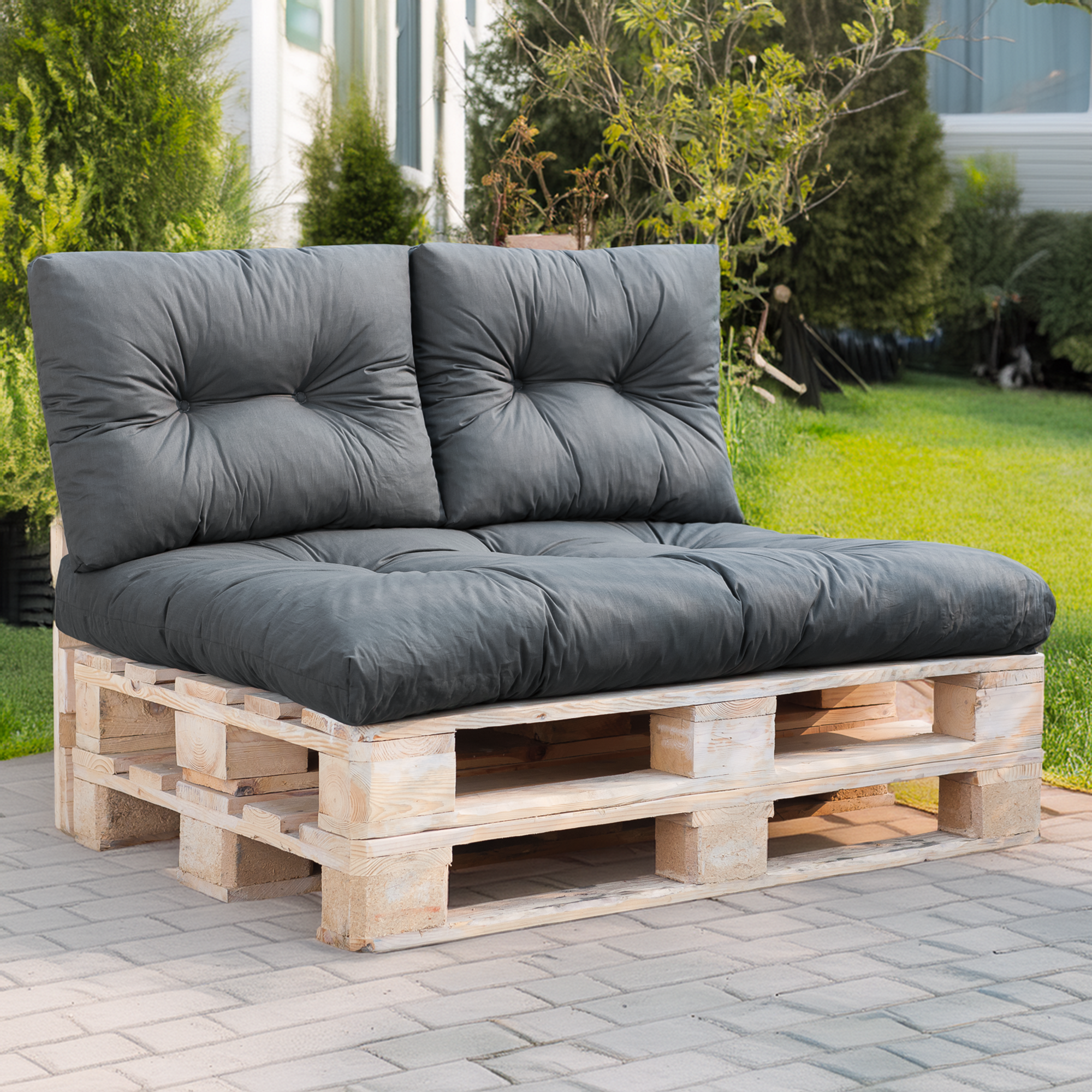 Szare poduszki Patio Termi na sofie z palet w ogrodzie.