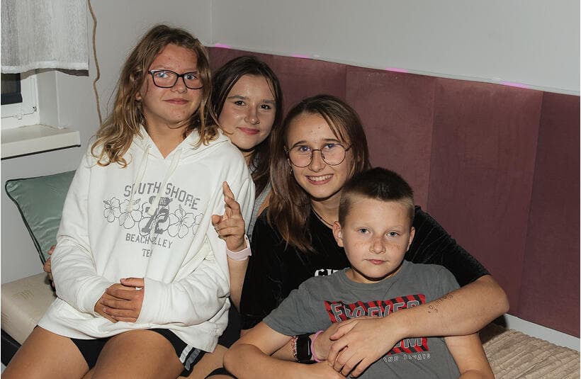 Wychowankowie ośrodka w odnowionym pokoju siedzą na łożku