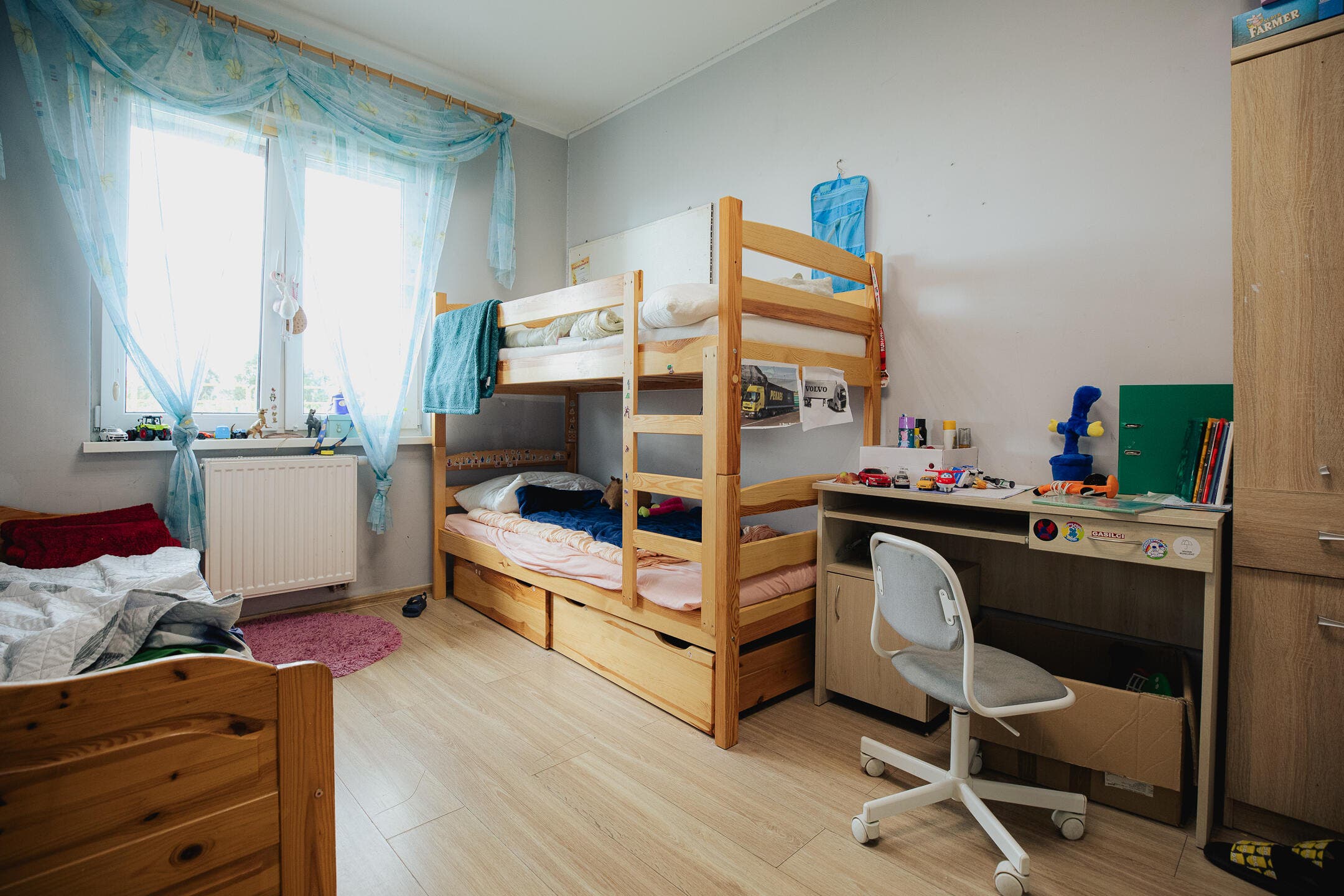 zdjęcie pokoju remontowanego przez Fundację Leroy Merlin, na zdjęciu widać biurko, łóżko dwupiętrowe i część pojedynczego, oraz okno
