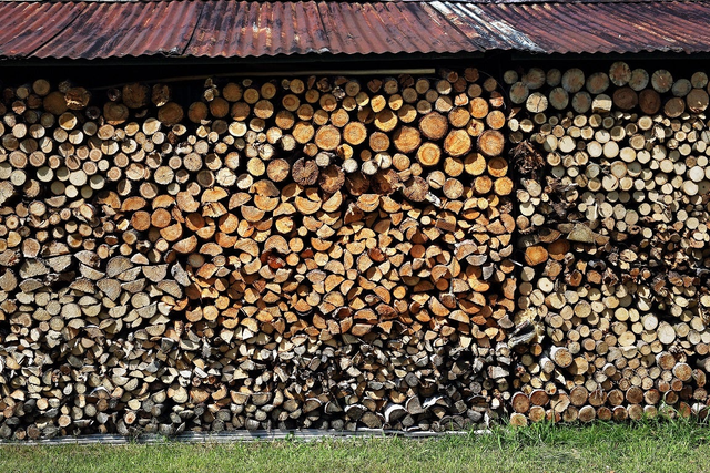 Ułożone drewno kominkowe w stosie przygotowane do sezonowania i opału.