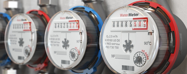 Elektroniczny wodomierz z wyświetlaczem cyfrowym zamontowany na instalacji wodnej.