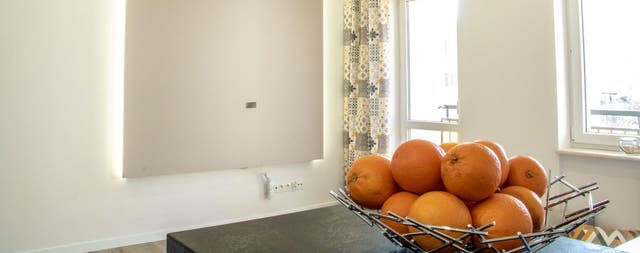 Nowoczesny salon po remoncie z podwieszanym sufitem z płyt gipsowo-kartonowych, podświetleniem LED i halogenami wpuszczanymi w zabudowę sufitową.