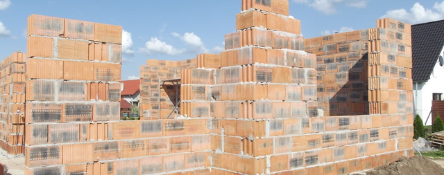 Ściany domu jednorodzinnego w trakcie budowy z pustaków ceramicznych.