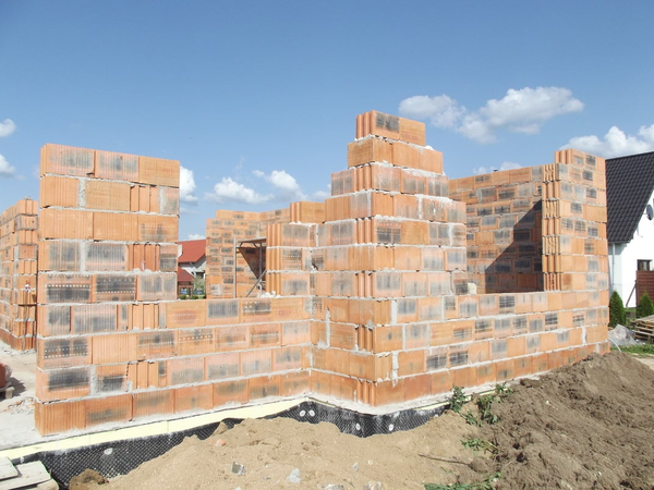 Ściany domu jednorodzinnego w trakcie budowy z pustaków ceramicznych.