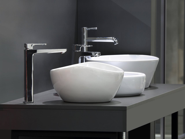 Ceramiczne umywalki na czarnym blacie w łazience pomalowanej na czarno.
