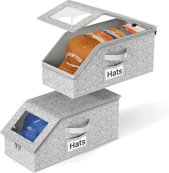 Deux boîtes de rangement empilables pour casquettes de baseball, pouvant contenir jusqu'à 24 casquettes. En carton gris.
