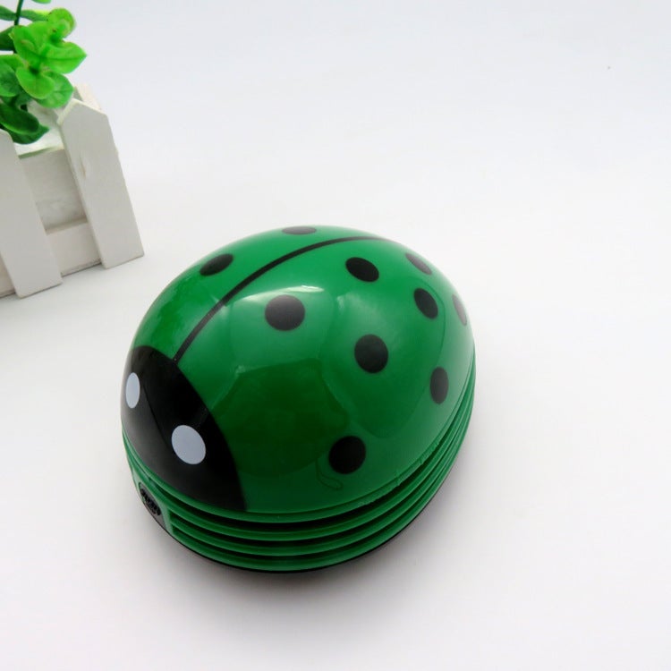 Miniaturowy, zielony odkurzacz biurowy w kształcie biedronki, idealny do domu i biura.