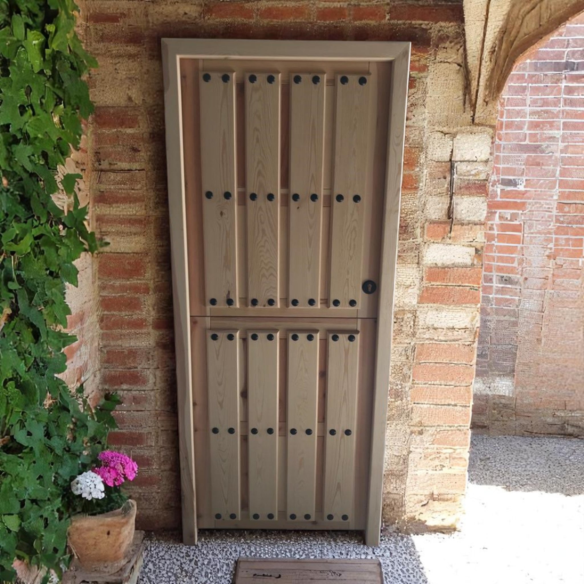 Puerta rústica de exterior con hoja partida ciega de madera con clavos