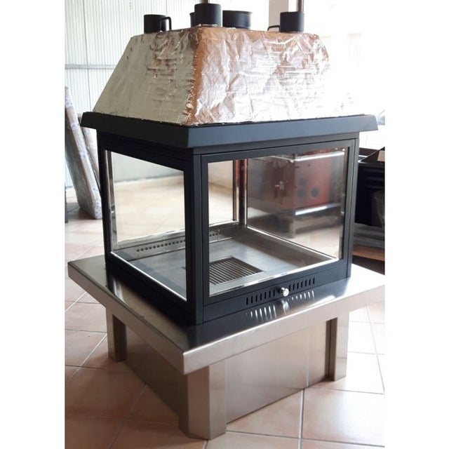 Czterostronny kominek opalany drewnem z okapem promiennikowym